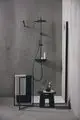 Duschsystem von Ideal Standard mit schwarzem Duschkopf, Handbrause und minimalistischem Design. Klare Trennwand und schlichte Ablage für Pflegeprodukte im Badezimmer.
